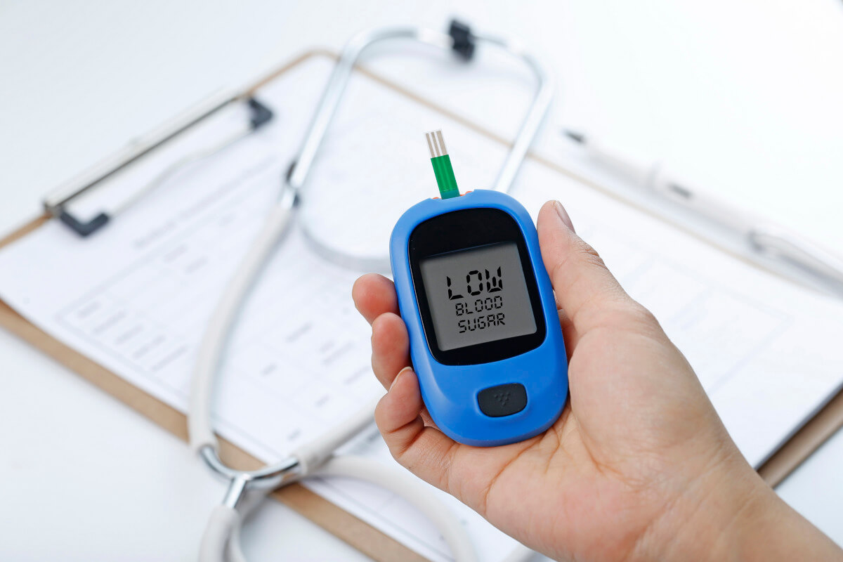 hand holding-blood glucose meter measuring blood sugar background is stethoscope
