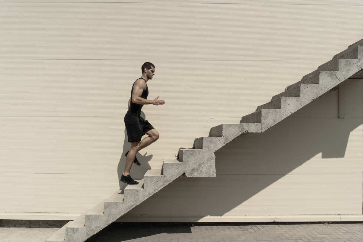 full length shot healthy athletic man climbing up stairs