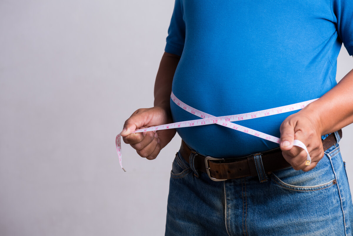 overweight fat adult man very tight jeans with measuring tape