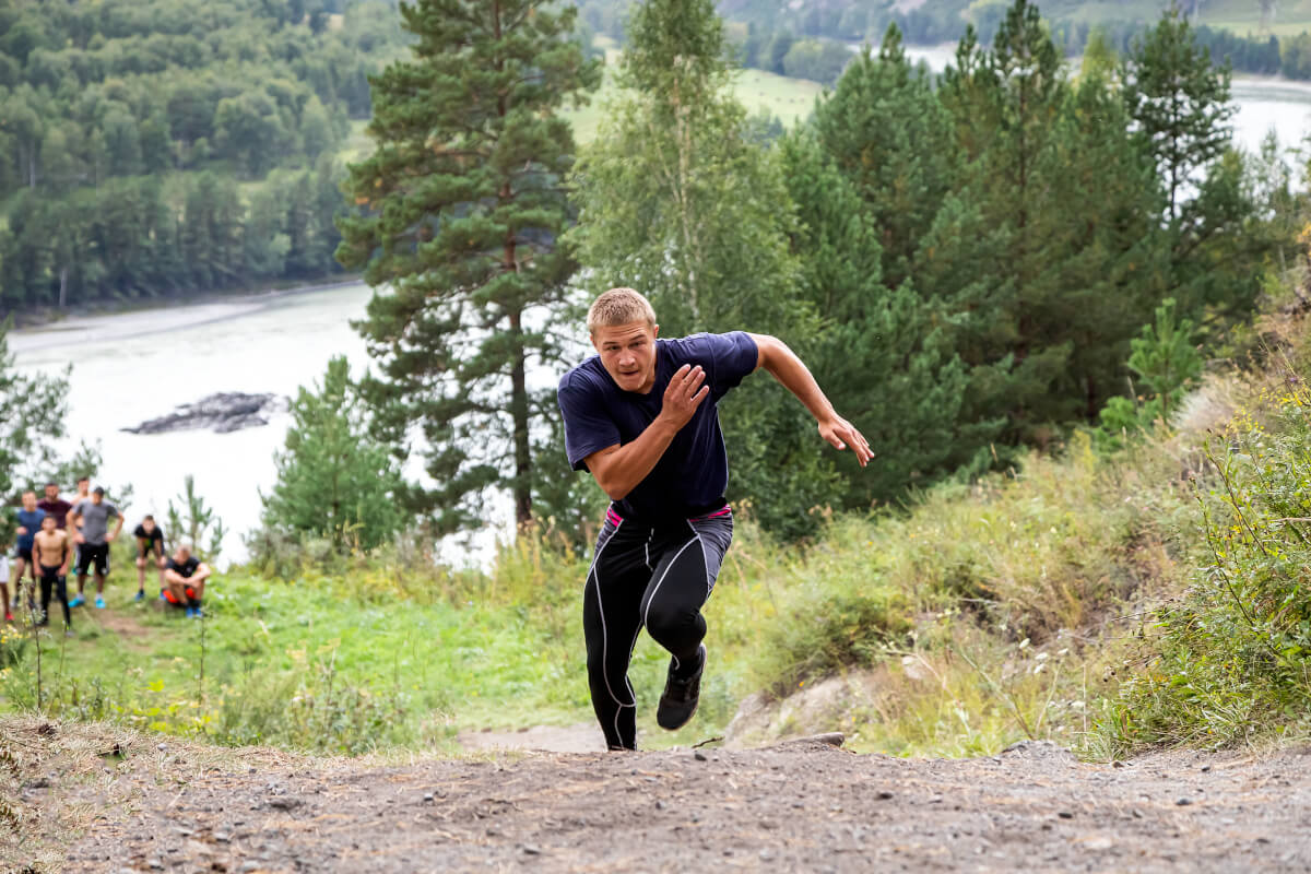 sportsman athlete runs uphill background mountain river mountains forest sprint race fast moving running effect blur
