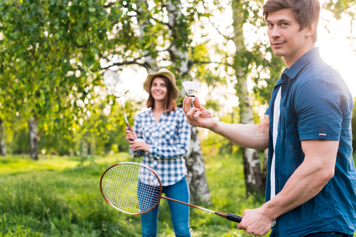 adult couple playing badminton park