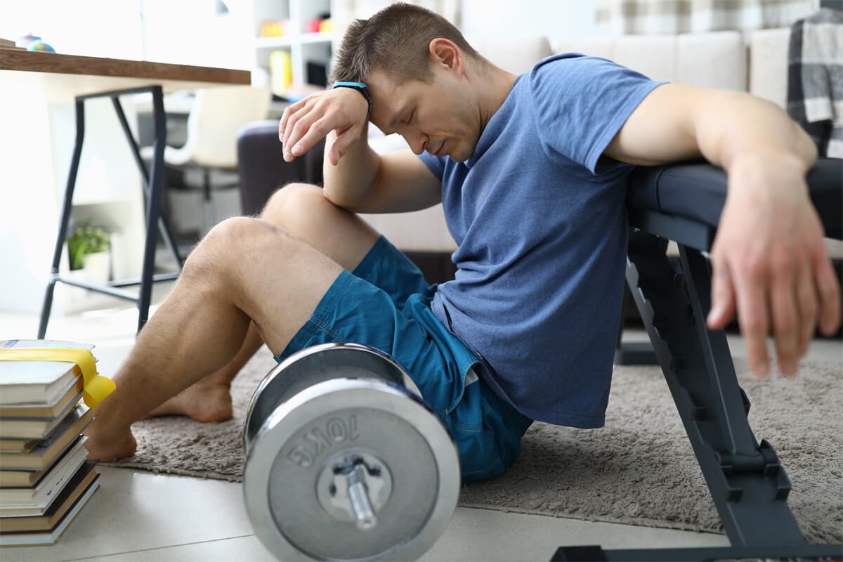 tired from sports exercises guy sits floor home