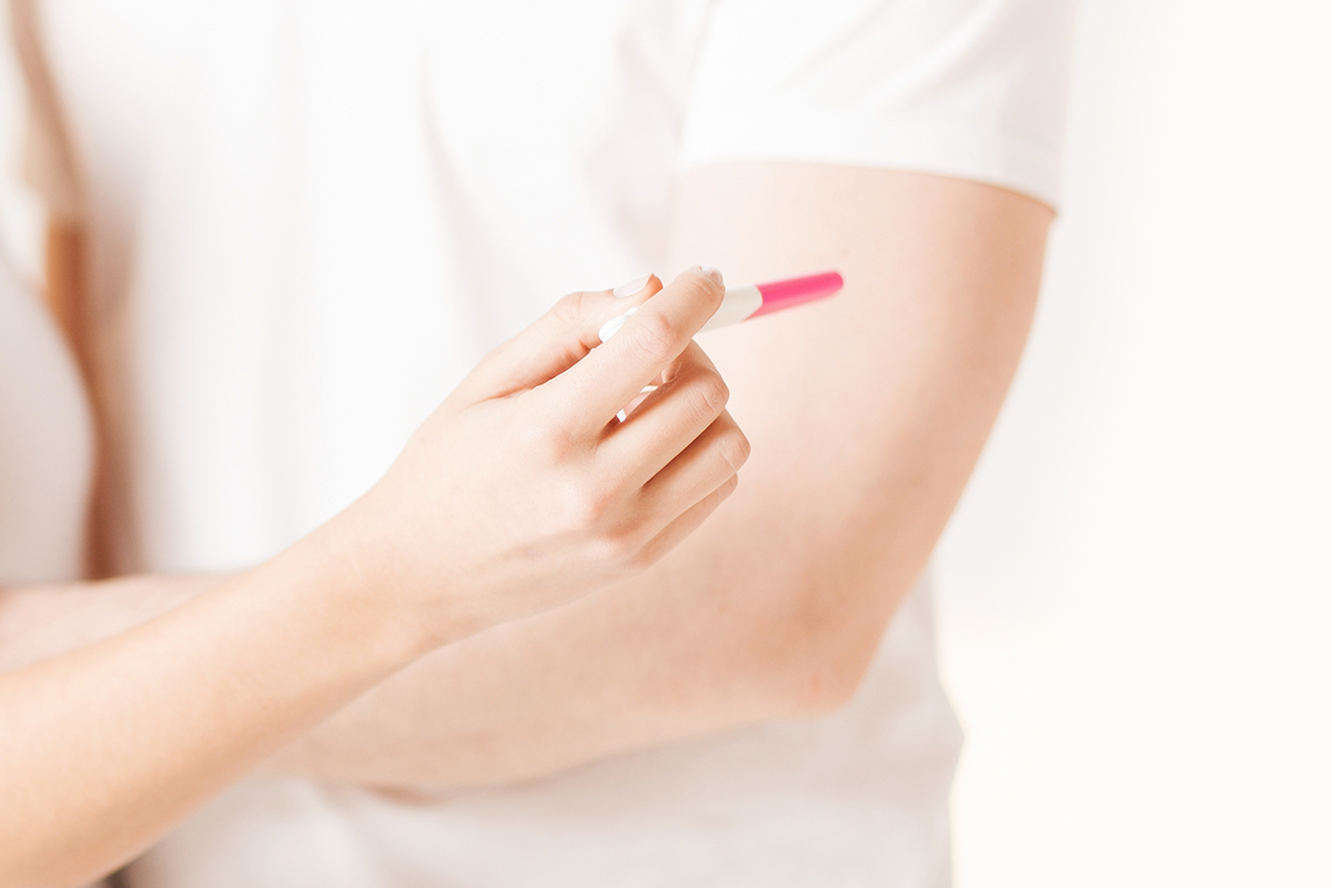 close up woman man hands with pregnancy test